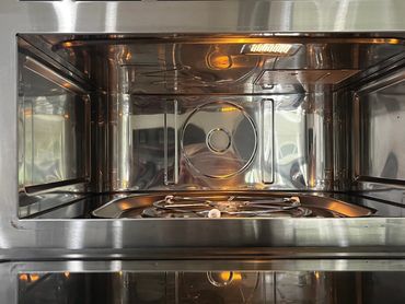 Open stainless steel microwave oven with interior light on.jupiter fl