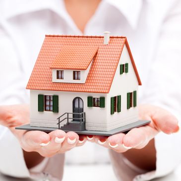 Professional female holding small house