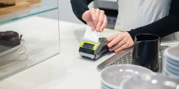 Cahiers ripping paper receipt off from the pos machine.