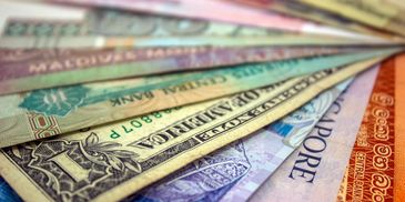 Paper notes from different countries piled up on top of each other.