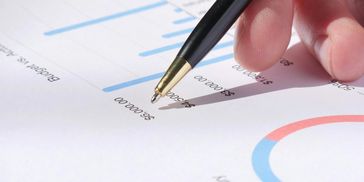 Pen on a page with lots of charts.