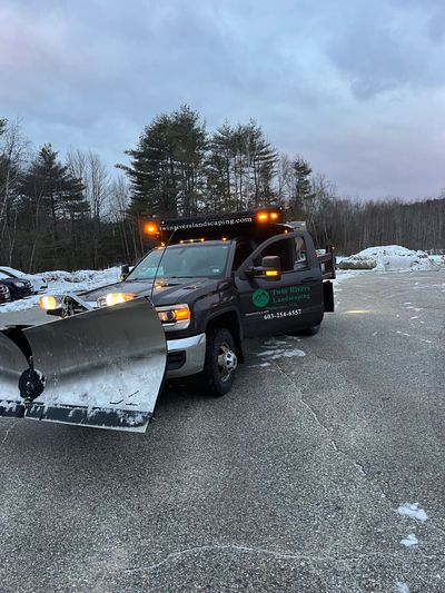 Twin River Landscaping work vehicle with a snow plow attached to the front.