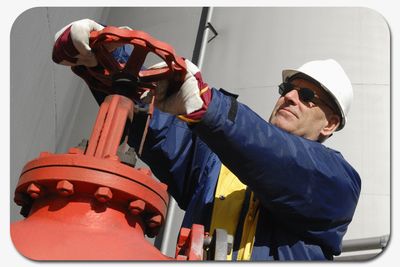 Industrial worker closing process flow valve.