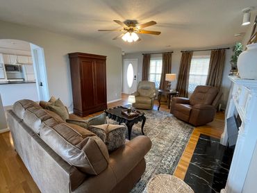 Cozy living room with leather furniture and a classic wooden cabinet.