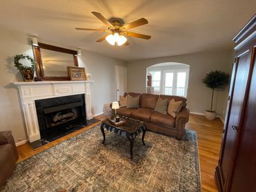 Cozy living room with leather sofa and elegant fireplace.