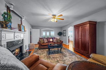 Cozy living room with fireplace, leather sofa, and wooden armoire.