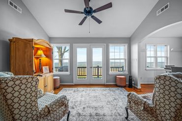 Cozy living room with patterned armchairs and a scenic view through glass doors.