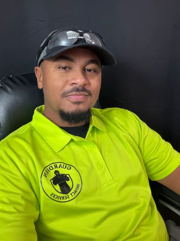 Man in bright yellow Guardian Impact Services shirt and cap with sunglasses.