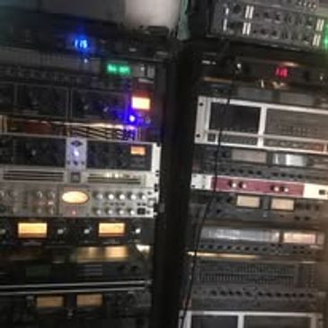 Rack-mounted audio and electronic equipment with illuminated display lights.