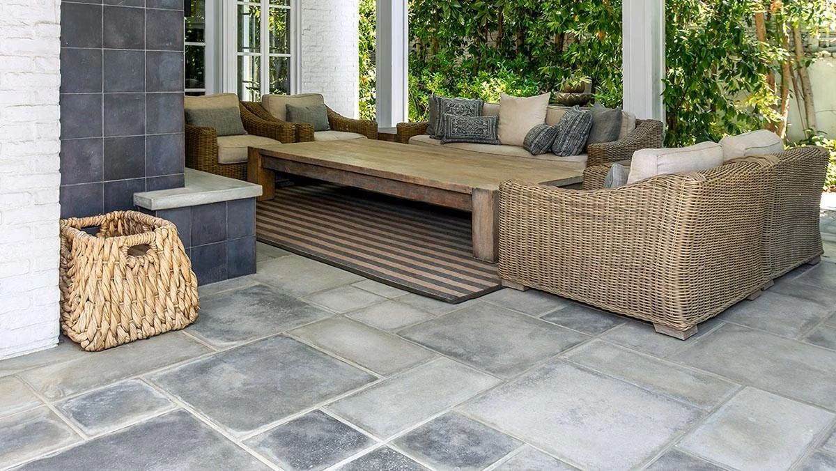 Outdoor seating area with wicker furniture and a large wooden table.