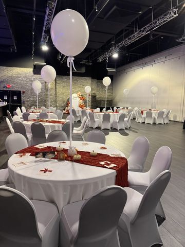 Long Island baby shower balloon decor featuring elegant white helium balloon centerpieces and a custom organic balloon backdrop in warm neutral and rust tones.