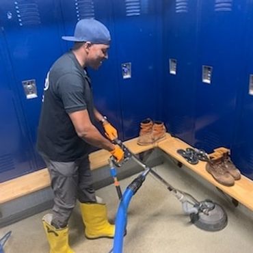 Company owner, Peter Smith, cleaning locker room floors.