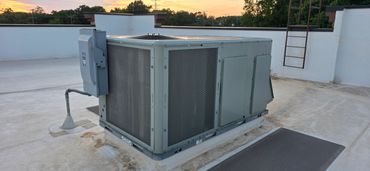 Large HVAC unit installed on a rooftop during sunset.