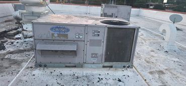 A rooftop HVAC unit with weathered surface and ventilation components.