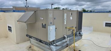 Large commercial HVAC unit installed on a rooftop under cloudy skies.
