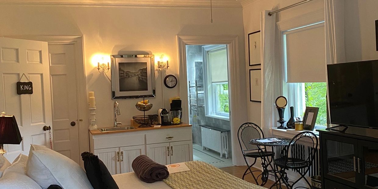 a room with one bed, a sink, and a bathroom