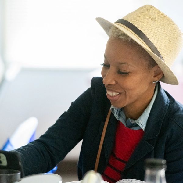 Person wearing a hat smiling indoors.
