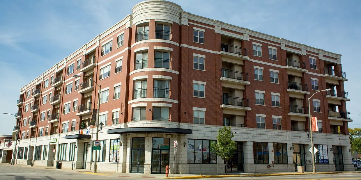 Modern brick apartment building on a street corner.