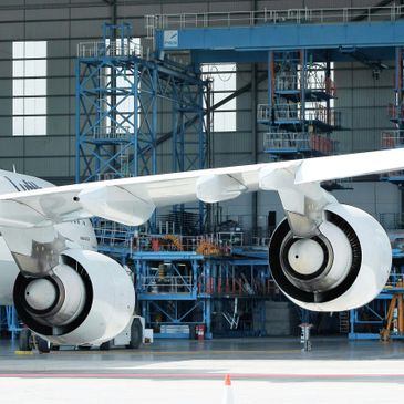 Close-up of an Airbus A340-600 wing and engines in a hangar.