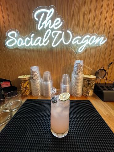 The social wagon Logo sign with a pink mocktail infront