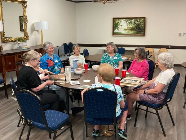 A group sitting around a table, laughing during a social hour