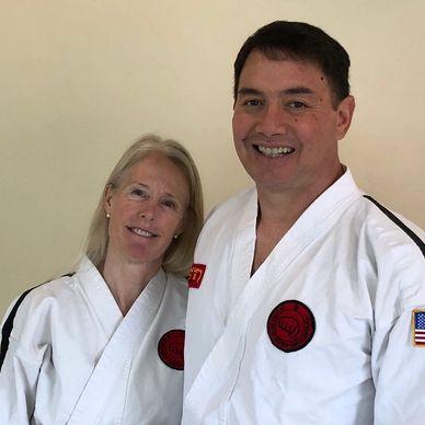 man and woman in tae kwon do uniforms smiling at the camera