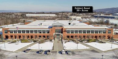 Large brick commercial building with parking and snowy landscaping.