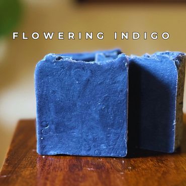 Two indigo-colored soap bars on a wooden surface with text 'Flowering Indigo'.