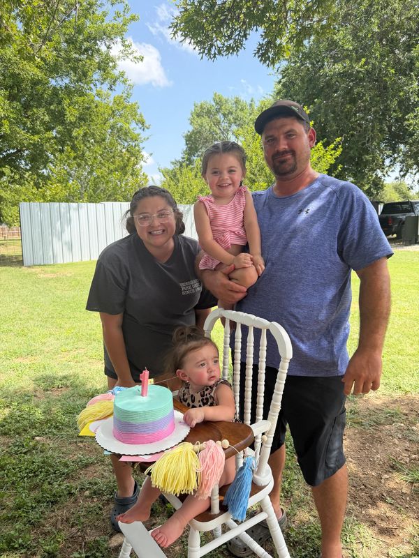 Family celebrating a child's birthday outdoors.
