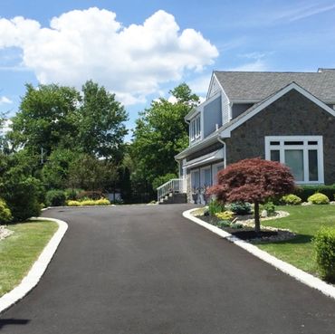 Entrée en asphalte fraîchement installée à Montréal, avec une finition uniforme et des bordures clai