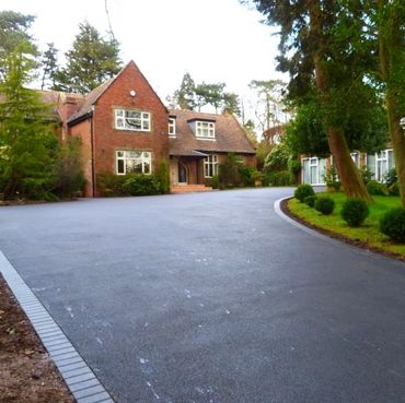 Entrée en asphalte combinée à des bordures en pavé à Laval, créant une finition élégante et durable