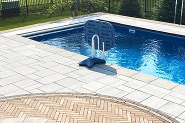 Installation de pavé uni autour d’une piscine creusée avec finition durable et antidérapante