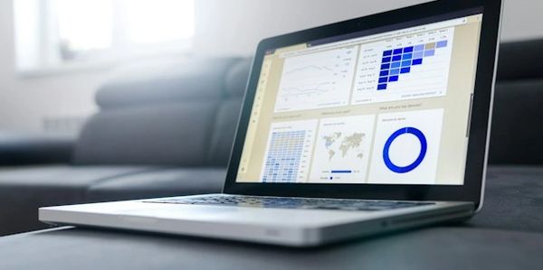 A laptop on a sofa displaying a business report