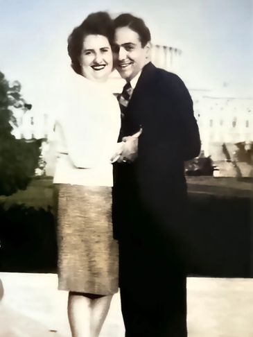 Photo of a man and woman embracing in front of the US Capital Building.
