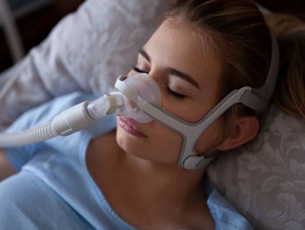 Woman with sleep apnea sleeping with a cpap/bipap. 