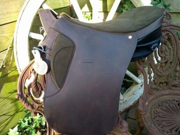 Close-up of a brown saddle on a wooden wheel.