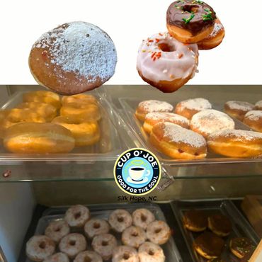 Various donuts displayed in trays with a coffee shop logo for Cup O' Joe in Silk Hope, NC.