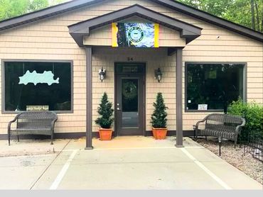 Small coffee shop entrance with benches and potted plants.
