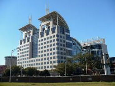 Modern office building with unique architectural design under blue sky.