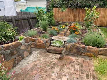 A charming garden with stone walls and colorful flowers.
