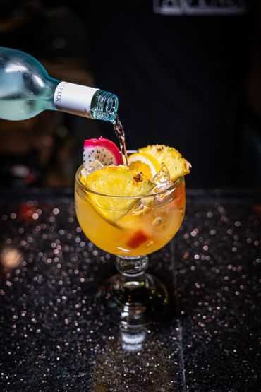 Refreshing tropical cocktail garnished with pineapple and dragon fruit.