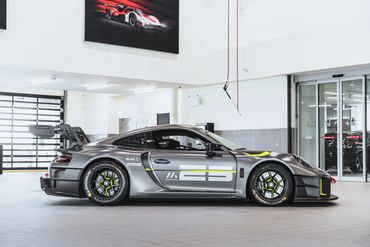 Sleek grey race car with number 25 in a bright showroom.