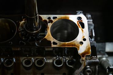 Close-up of an engine block with engine oil residue.