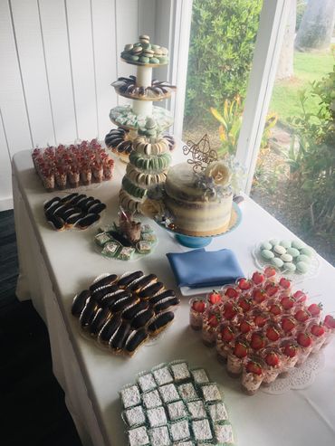 Exquisite Dessert Bar Display with Naked Cake, Strawberry Cheesecake Shooters, Eclairs, and Macarons