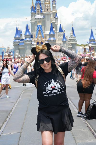 Woman with Mickey ears posing in front of a castle