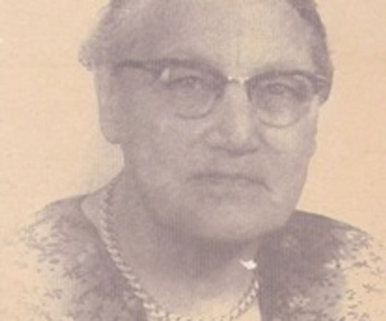 Black and white portrait of an elderly woman wearing glasses and a necklace.