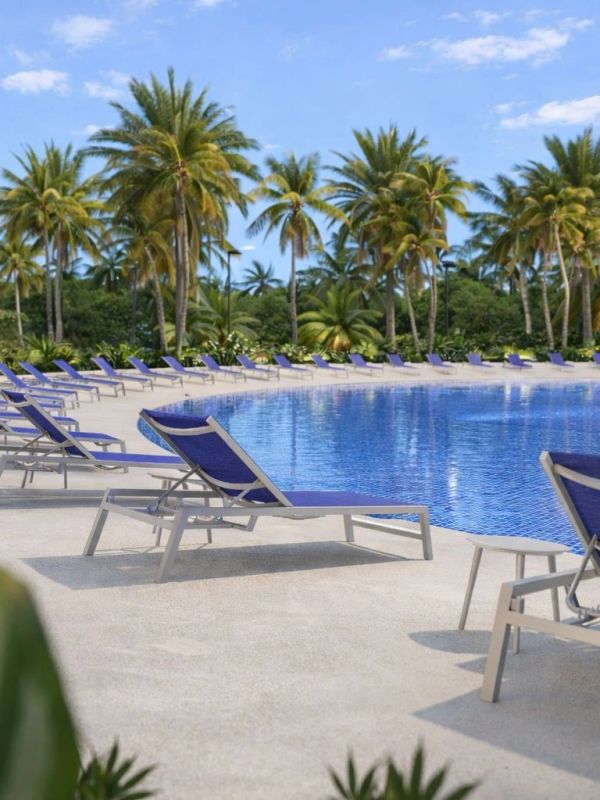 Poolside lounge chairs by a tropical pool with palm trees.