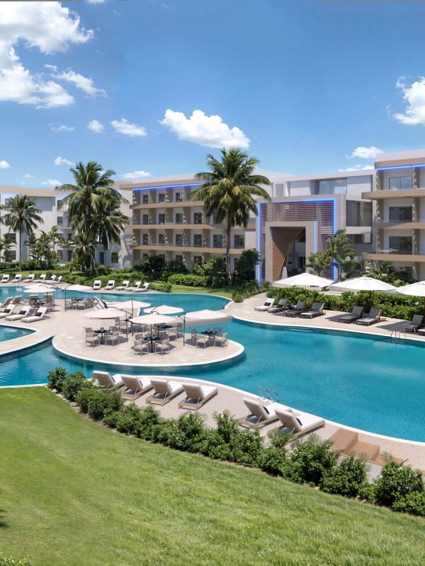 Modern resort with pool, palm trees, and lounge chairs under a clear blue sky.