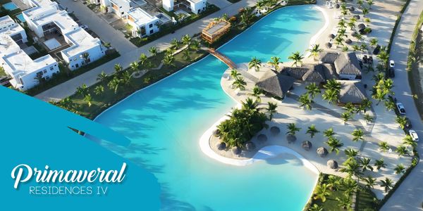 Aerial view of Primavera Residences IV with a large blue lagoon and modern white houses.