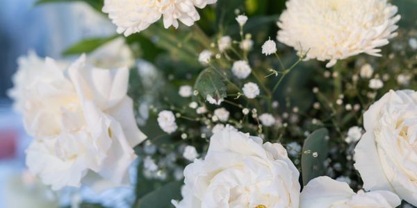 Close-up of white roses and chrysanthemums in a floral arrangement.